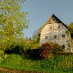 a white house sitting on top of a lush green hillside